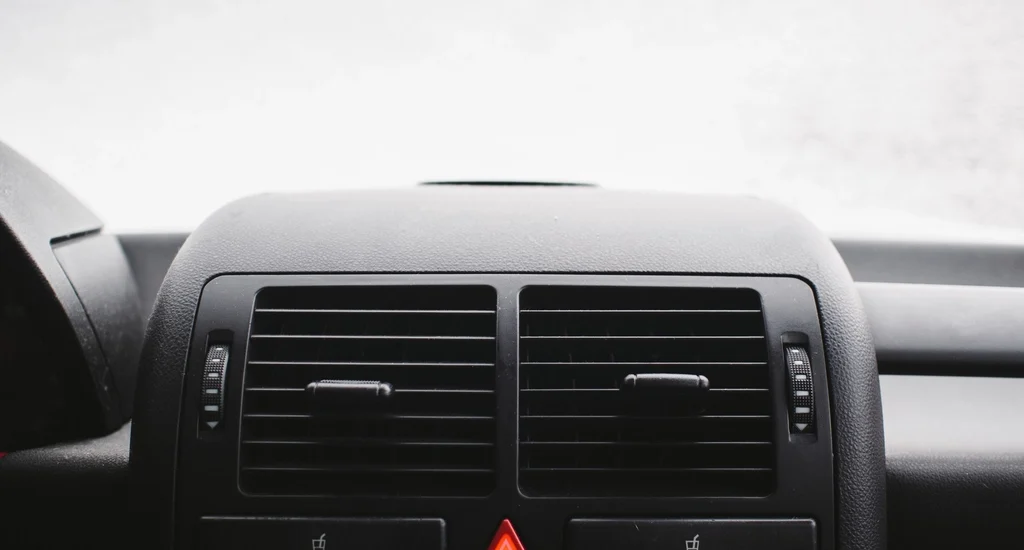 A car dashboard with the red hazard warning light button