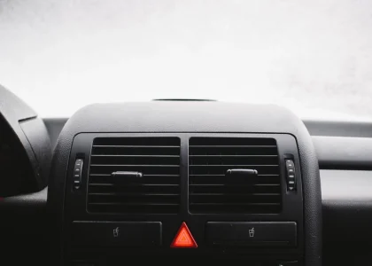 A car dashboard with the red hazard warning light button