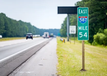 An Interstate 587 East mile marker sign beside a highway
